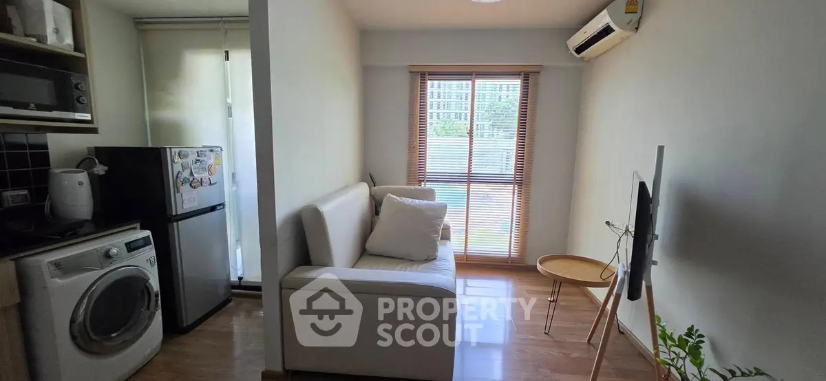 Cozy living room with modern appliances and natural light, perfect for urban living.