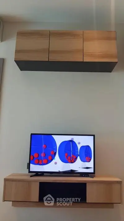 Modern living room with stylish wooden cabinets and flat-screen TV, perfect for contemporary home entertainment.