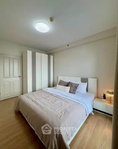 Spacious bedroom with modern decor and ample natural light, featuring a cozy bed and stylish wardrobe.
