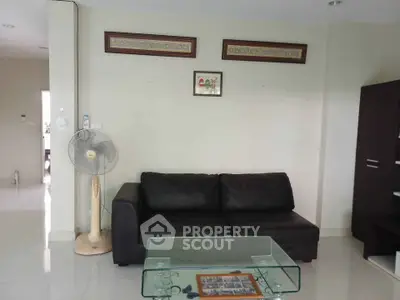 Modern living room with black leather sofa and glass coffee table