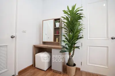 Stylish corner vanity with mirror and plant in modern bedroom