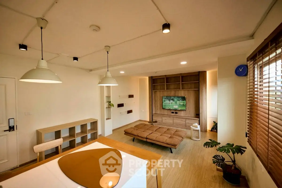 Modern living room with stylish decor and open layout, featuring a cozy seating area and contemporary lighting.