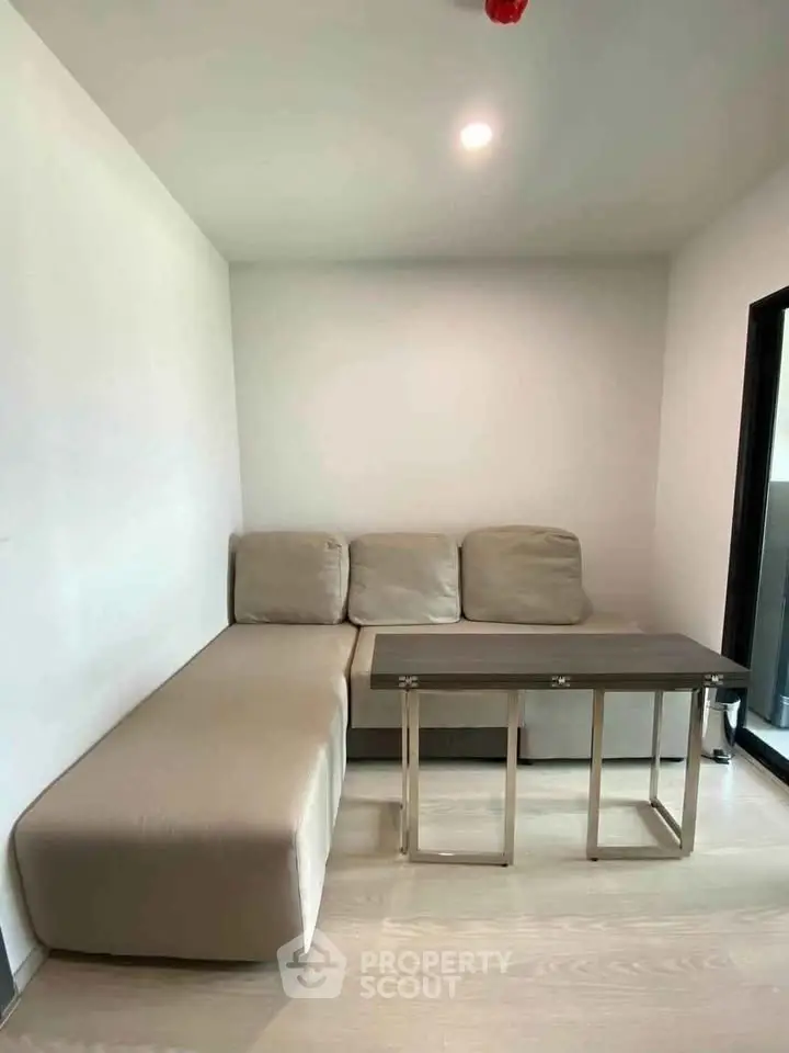 Cozy living room with modern beige sofa and sleek coffee table, perfect for relaxation.