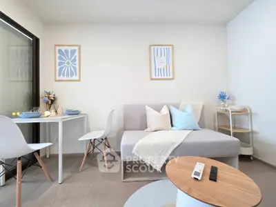 Modern living room with stylish decor and natural light, featuring a cozy sofa and dining area.