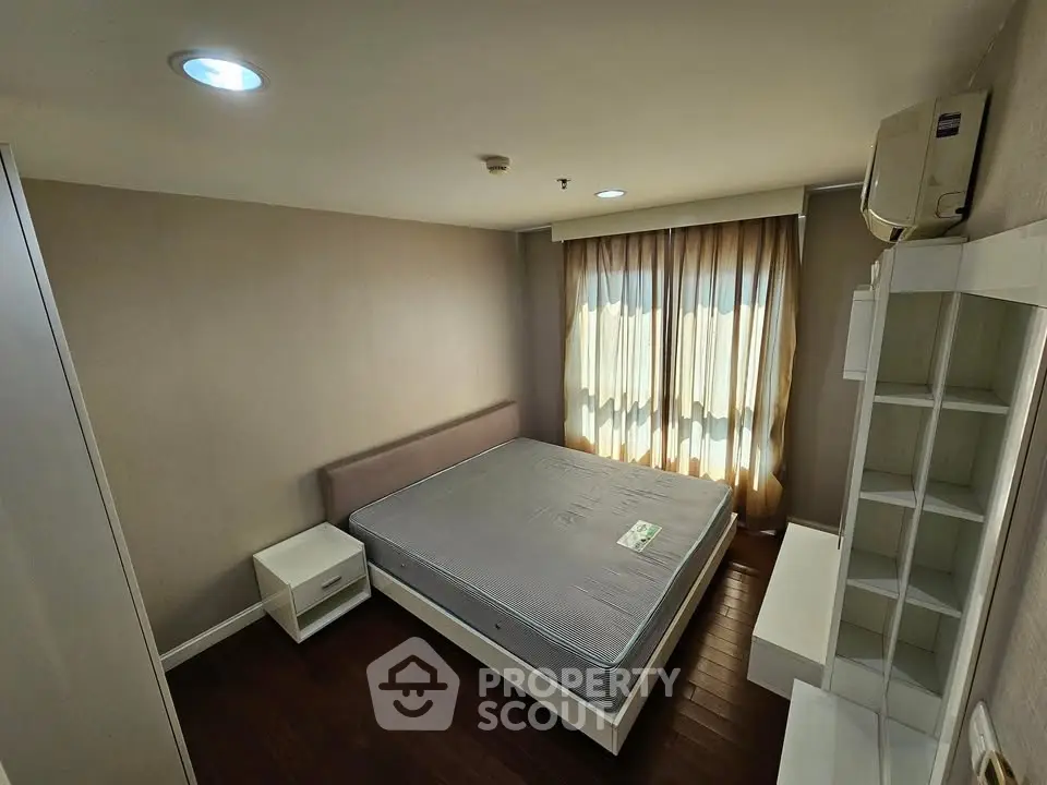 Spacious bedroom with modern furnishings and natural light, perfect for comfortable living.