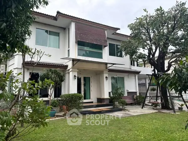 Charming two-story house with lush garden and modern facade