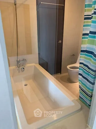 Modern bathroom with bathtub and striped shower curtain