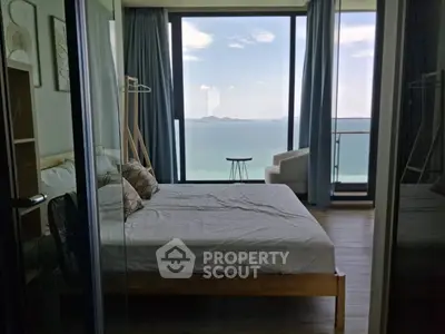 Luxurious bedroom with stunning ocean view and floor-to-ceiling windows in modern apartment.