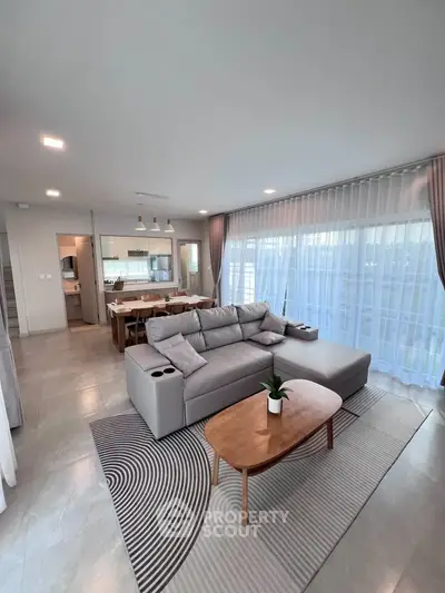 Spacious modern living room with elegant decor and large windows for natural light.