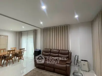 Spacious living room with elegant dining area and modern leather sofa, perfect for family gatherings.