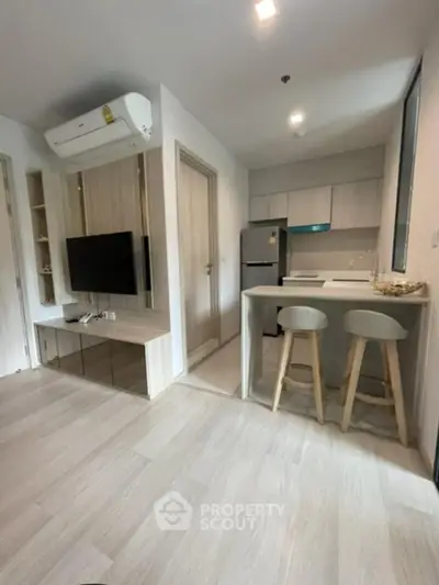 Modern open-plan living room with kitchen, featuring sleek furniture and contemporary design.