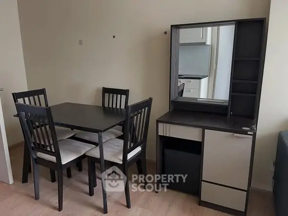 Modern dining area with sleek black table and chairs, adjacent to stylish storage unit.