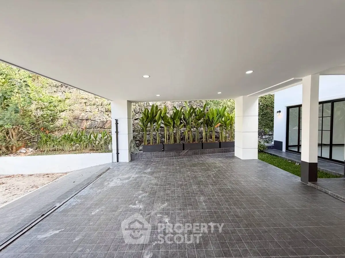 Spacious modern parking area with sleek tile flooring and lush greenery.