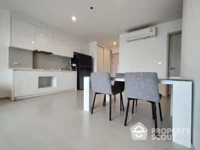 Modern kitchen with dining area and sleek appliances in a spacious open layout.