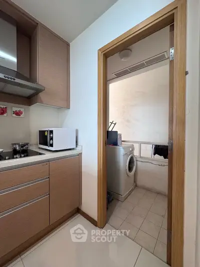 Modern kitchen with adjacent laundry area featuring a washing machine.