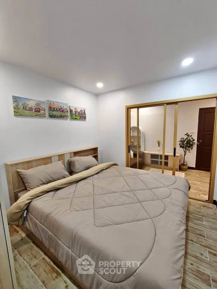 Cozy bedroom with modern decor and wooden flooring in a stylish apartment.