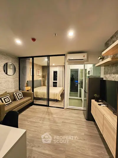 Modern open-plan living room with glass partition to bedroom, featuring sleek furniture and stylish decor.