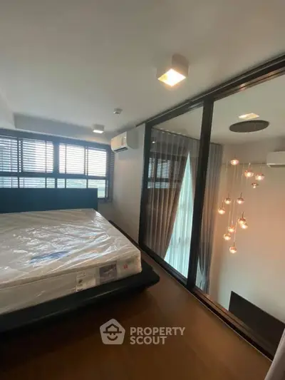 Modern bedroom with large windows and stylish lighting in a contemporary apartment.