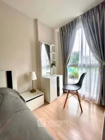 Bright bedroom with modern decor and large window offering garden view