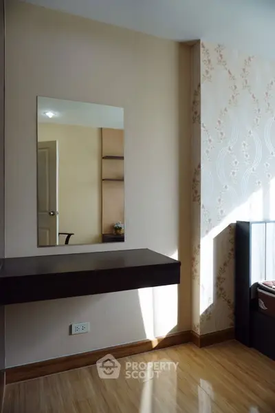 Charming bedroom corner with elegant wallpaper and sleek wooden flooring