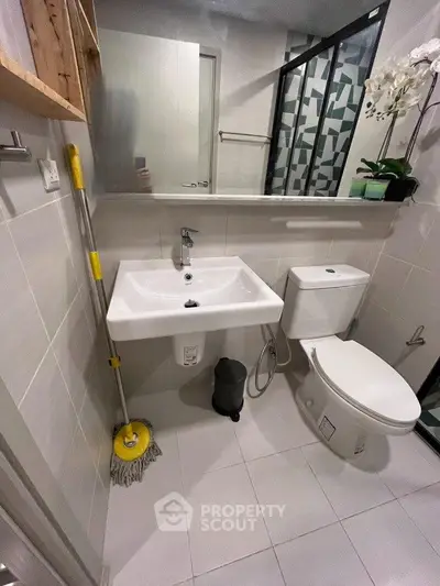 Modern bathroom with sleek fixtures and stylish tile design, featuring a compact layout and contemporary decor.