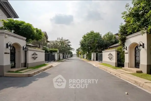 Luxurious gated community entrance with lush greenery and elegant design.
