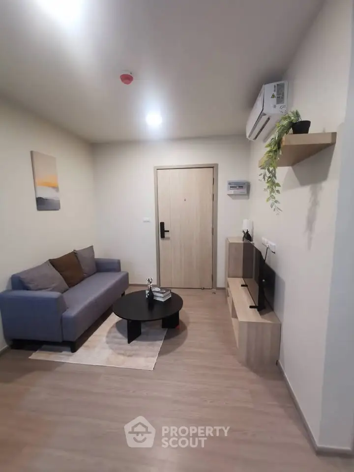 Modern living room with cozy sofa, TV, and stylish decor in a contemporary apartment.