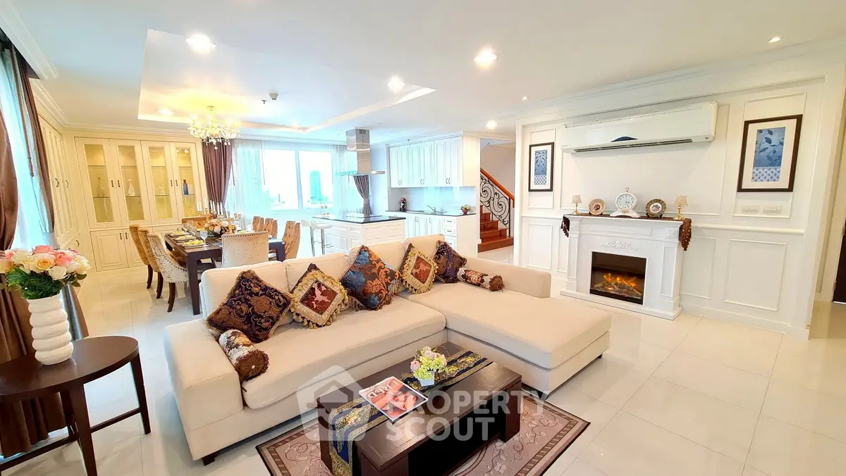 Luxurious open-plan living room with elegant decor and modern kitchen in a spacious apartment.