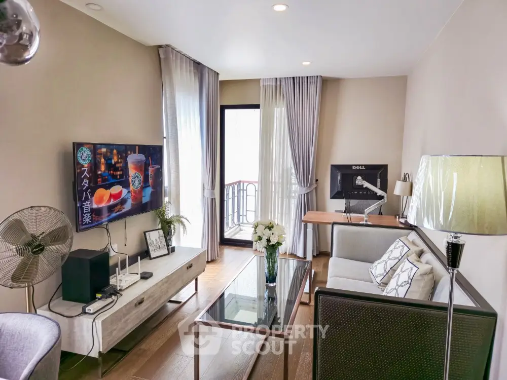 Spacious living room with modern furnishings, abundant natural light, and access to a cozy balcony, perfect for urban living.