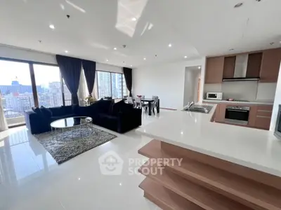 Spacious modern living room with open kitchen and city view