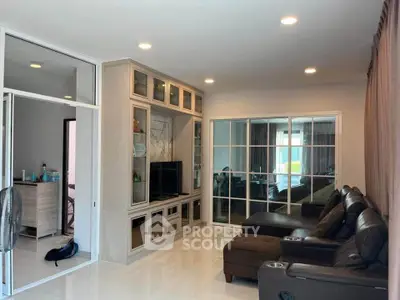 Spacious living room with modern furniture and built-in entertainment center.