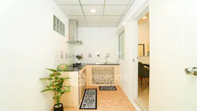 Modern kitchen with sleek design and gas stove, featuring stylish decor and ample natural light.