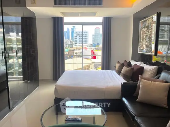 Modern bedroom with city view, sleek furnishings, and natural light.