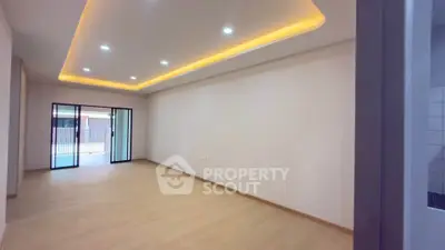 Spacious modern living room with recessed lighting and sliding glass doors to balcony.