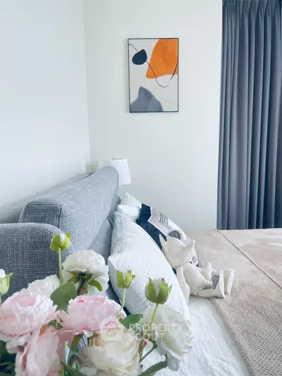 Elegant bedroom with modern decor, featuring a stylish bed, abstract art, and soft lighting for a cozy ambiance.