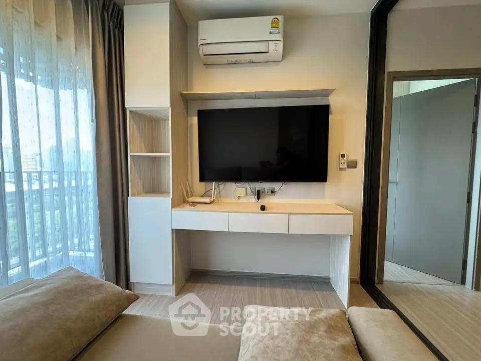 Modern living room with wall-mounted TV and air conditioning in a stylish apartment.