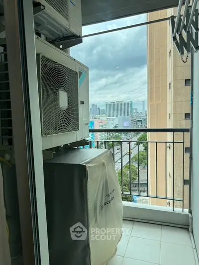 Compact balcony with city view and air conditioning unit in urban apartment