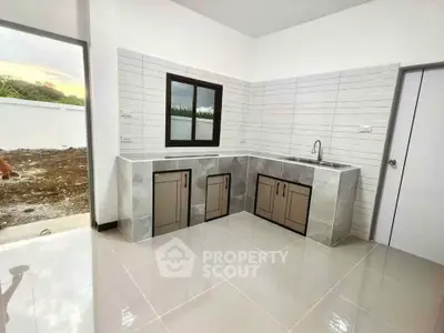 Modern kitchen with sleek tile design and ample natural light, perfect for culinary enthusiasts.