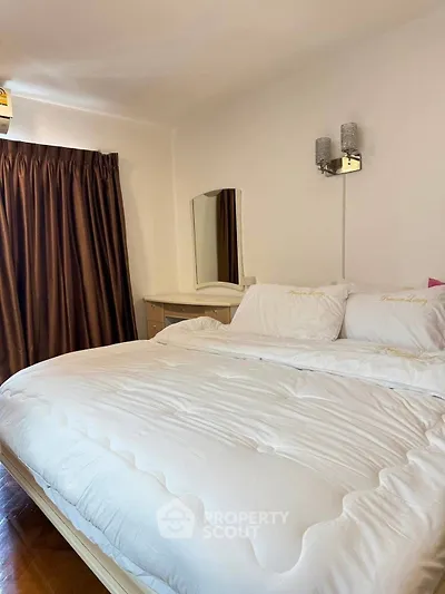 Cozy bedroom with elegant lighting and plush bedding in a modern apartment.