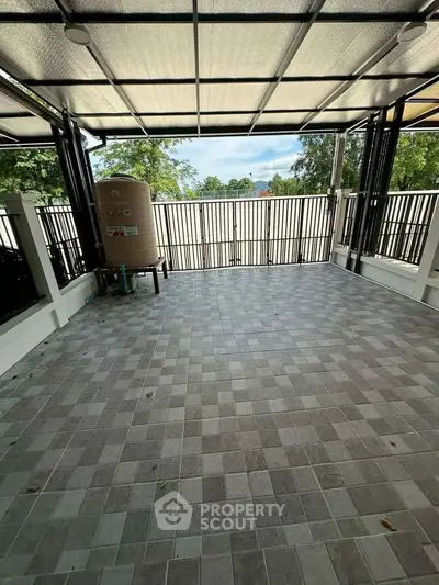 Spacious tiled balcony with metal railing and covered roof, perfect for outdoor relaxation.