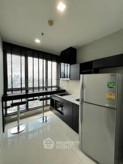 Modern kitchen with sleek black cabinetry and stainless steel appliances, offering a stunning city view.