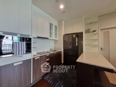 Modern kitchen with sleek cabinetry and black appliances in a stylish apartment.