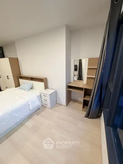 Modern bedroom with sleek furniture and natural light, perfect for a cozy living space.