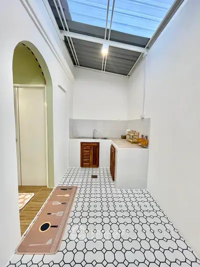 Charming small kitchen with unique tile flooring and skylight, perfect for cozy home living.
