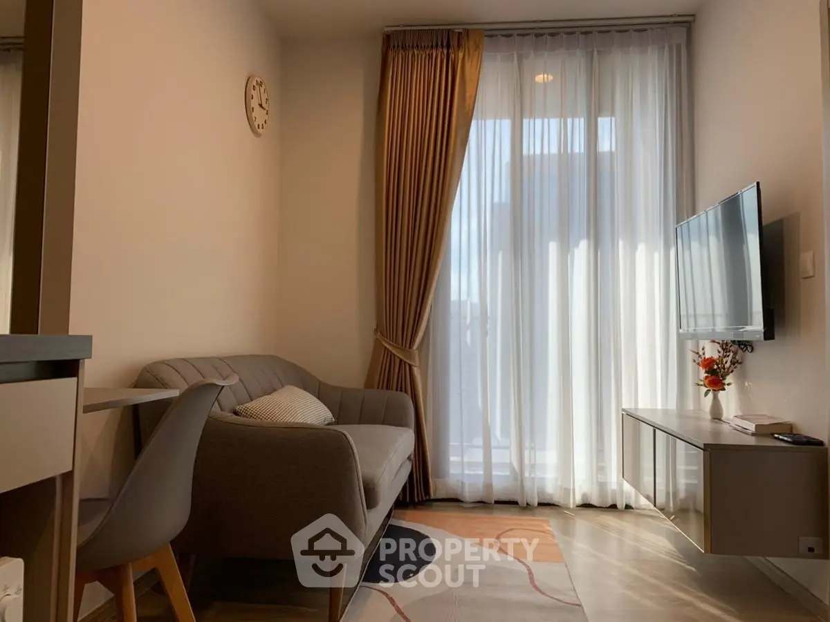 Cozy modern living room with stylish sofa and wall-mounted TV, perfect for relaxation.