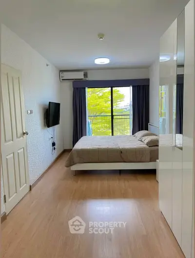 Modern bedroom with large window and stylish decor, perfect for relaxation and comfort.