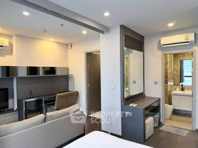 Modern studio apartment with open layout, featuring a cozy living area and stylish bathroom.