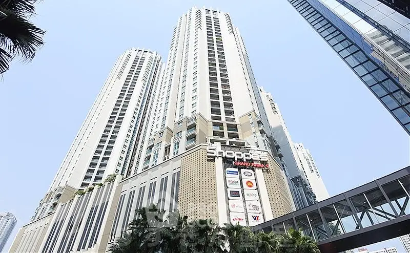 Stunning high-rise building with modern architecture and retail spaces in vibrant urban setting.