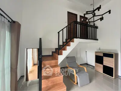 Modern duplex living room with stylish staircase and cozy seating area