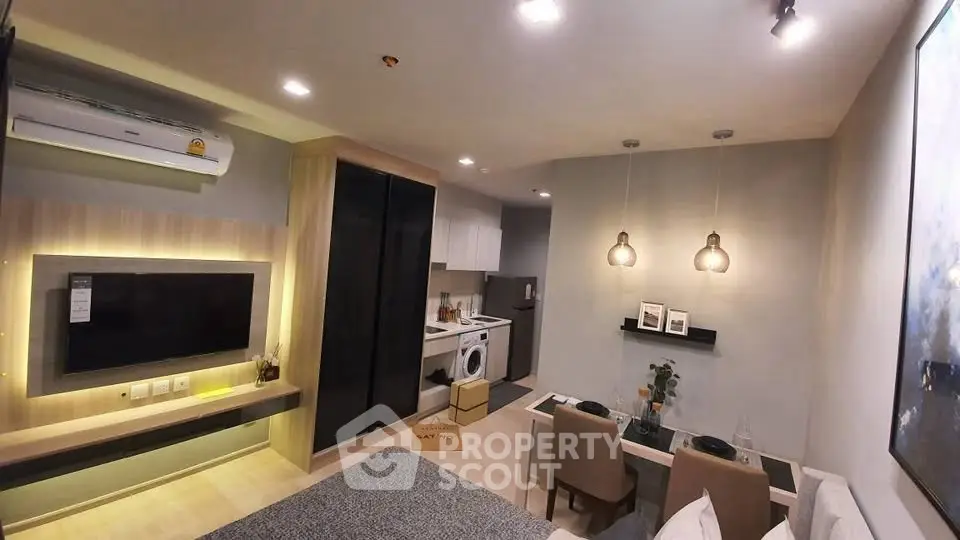 Modern living room with open kitchen, featuring sleek design and cozy ambiance.